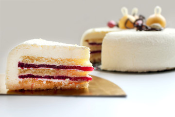 Sliced Christmas winter white textured cake with orange mousse decorations, almonds and cranberries