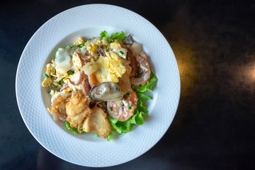 Stir-fried rice noodle with seafood such as prawn, mussel, fried fish, squid. (Kuaitiao khua kai) Thai fried rice noodle top view.