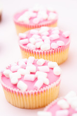 Colorful cupcakes on a pink background.