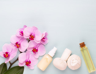 Fototapeta na wymiar Sea salt, aromatherapy oil in bottles and orchid on vintage wooden background.