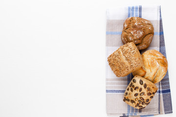 Gold rustic crusty loaves of bread and buns on wooden background. Still life captured from above top view, flat lay.