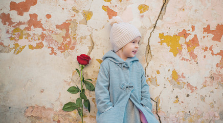little girl in vintage coat. valentines day. romantic date. small kid has red rose. happy childhood. retro fashion. happy birthday. wedding. love present. childrens day. Valentine rose from him