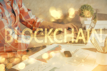 Crypto currency theme hologram with businessman working on computer on background. Concept of blockchain. Multi exposure.