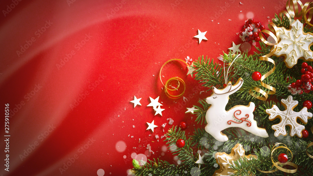 Poster beautiful christmas red background with green fir branches and ginger cookies in white glaze in form