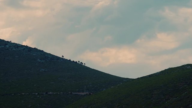 Time Lapse Of Green Hills In Rural Greece, Recovering After A Bushfire With Only A Few Trees Left Standing On The Rim With Pink Clouds At Sunset.