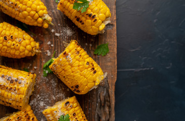 Grilled corn with greens and salt on the background of concrete, snack or dinner, breakfast