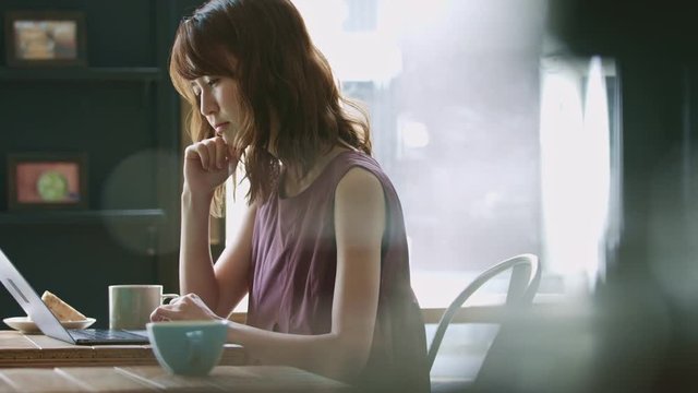 悩む女性・パソコン・カフェ