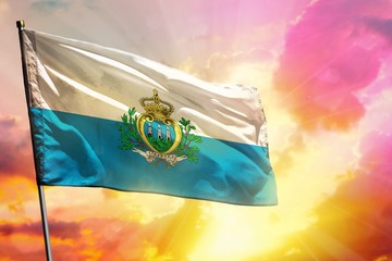 Fluttering San Marino flag on beautiful colorful sunset or sunrise background. Success concept.