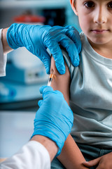 pediatrician injecting a subcutaneous vaccine to a child in the medical office