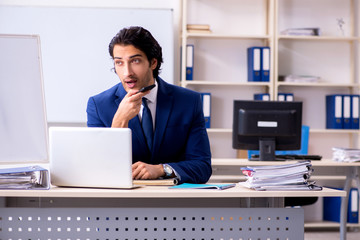 Naklejka premium Young handsome businessman working in the office