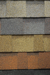 The texture of multi-colored tiles for the roof of the building. Crumbs of asphalt and rubber