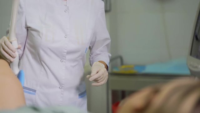 Doctor gynecologist preparing sensor for ultrasound of the vagina. The patient is examined by a gynecologist. Ultrasound of the pelvic organs.