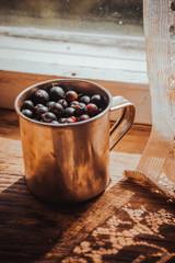 Stainless steel cup with sweet summer berries in the daylight