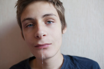 Portrait of a teenager boy flowing saliva from his mouth