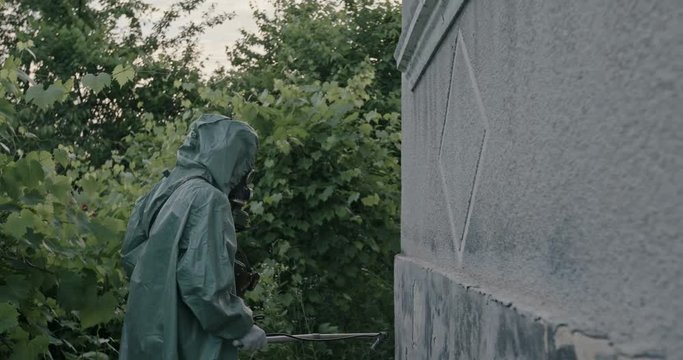 Anonymous guy in hazmat suit searching radiation on house