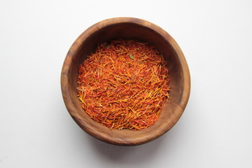 Dry marigold petals spice in wooden bowl on white background
