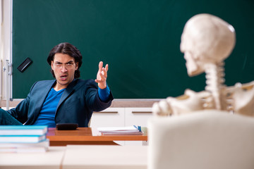 Male teacher and skeleton student in the classroom 