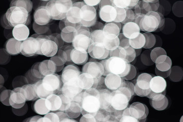 Abstract defocused blurred background consisting of white bright lights. The pattern created by the lens, beautiful bokeh. Pattern of a large number of round lanterns. Background for design.