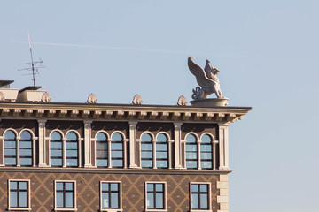 Modern architectural stylish residential building with a stone sculpture of a griffin on the roof....