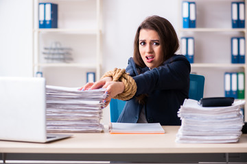 Young beautiful employee tied up with rope in the office 