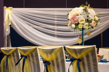 Wedding table decorated with flowers, beads, lemon. With blue track on the table. Yellow flowers.