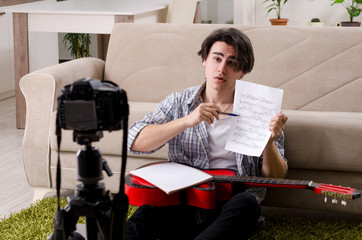 Young guitar player recording video for his blog 
