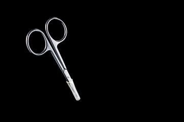 Neat little scissors for manicure and pedicure on a black background, isolate