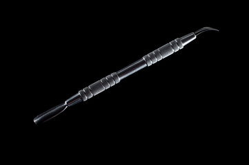 Pusher for manicure and pedicure on a black background, isolate