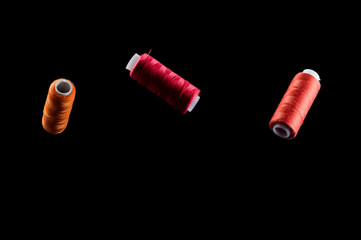 Orange, red and pink threads floating in the air on a black background, isolate