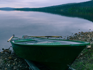 Boat on the shores of the northern lake in the taiga