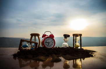 Hourglass Passing of Time Lapse Clouds. An hourglass in front of a bright blue sky with puffy white...