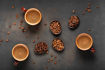 Three cups with fresh and aromatic coffee and coffee beans on the table