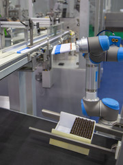 Automation robotic arm load aluminum tube to cosmetic tube filling machine in production line