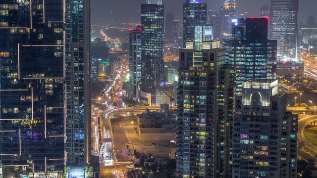 Aerial top view of Dubai Marina night transition timelapse. Media city district on a background in Dubai, UAE. Illuminated modern towers and traffic on the road