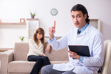 Young female patient discussing with male psychologist personal 