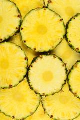 Pineapple juicy yellow slices background. Top view.
