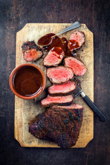 Barbecue dry aged wagyu tri tip steak with grill rub for smocking as top view on a old cutting bord