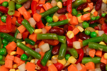 Sliced vegetables, corn, beans, peas, carrots, sweet peppers background.