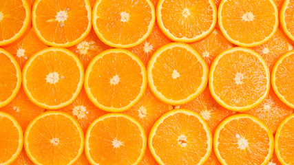 Slices of oranges as a background, top view.