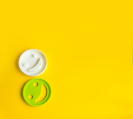 Smiley in woman's hands on yellow background with copy space. Happy work day concept