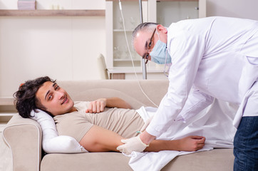 Obraz premium Old male doctor visiting young male patient 
