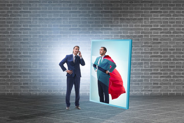 Businessman seeing himself in mirror as superhero