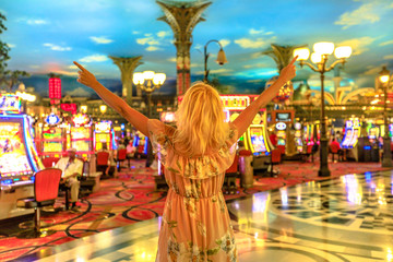 Heureuse femme caucasienne gagnante au casino de Las Vegas, Nevada, USA. Dame blonde appréciant dépenser de l& 39 argent et avoir la chance de gagner. Arrière-plan flou d& 39 architecture. Concept de toxicomane de jeu.