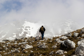 hiker on mountain peak in matese park and fog