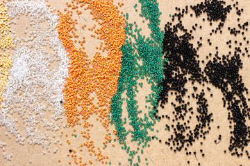 Different color Mardi Gras beads scattered on top of each other, giving a vibrant color splash background. Scattered colored beads. Multi-colored beads scattered on the table