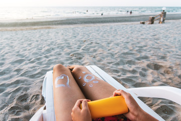 Woman using sun lotion on the beach