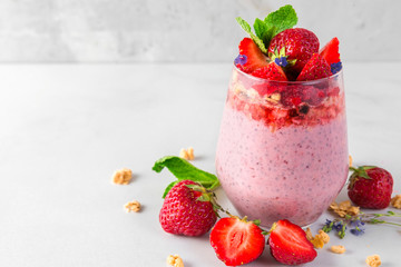 healthy delicious breakfast dessert. strawberry yogurt or chia seed pudding with granola, fresh berries and mint