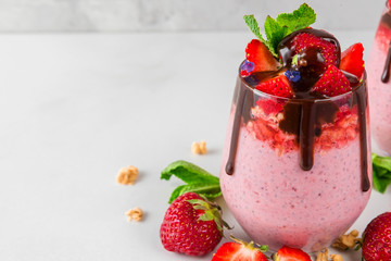 strawberry chia seed pudding with yogurt, chocolate, fresh berries and mint for healthy tasty breakfast