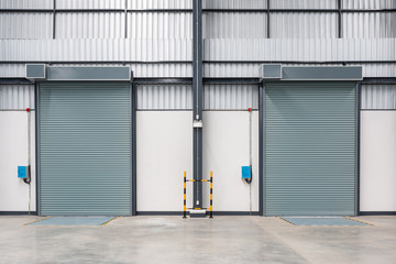 Fototapeta na wymiar Roller shutter door and concrete floor inside factory.