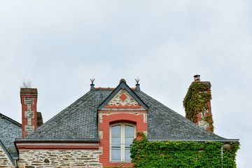 Facade of old colorful house, roof and attic window in Rochefort-en-Terre, French Brittany
